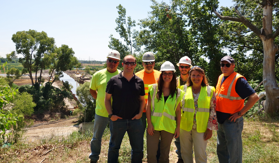 Zephyr project partners stand in construction gear in front of the remediation site