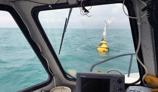 floating yellow buoy can be seen in water through a boat window