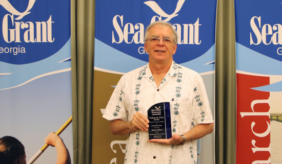 Brian Miller holds the William Q. Wick Award from the Sea Grant Extension Assembly