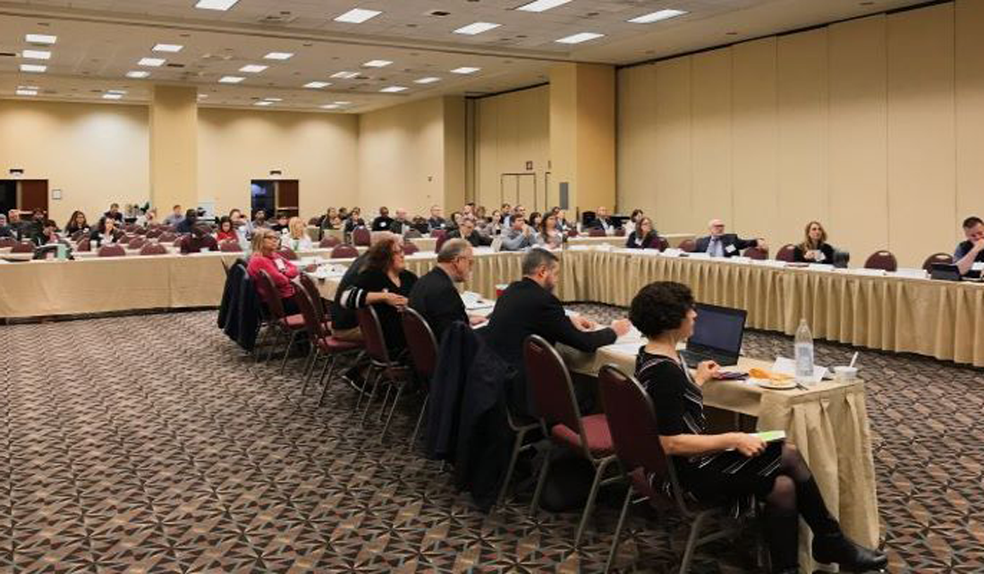 people sitting at tables in a large conference room