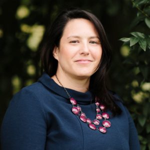 headshot of dark-haired woman with trees in the background