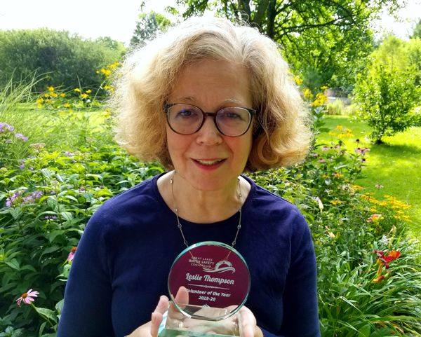 Leslie Dorworth holding up volunteer award