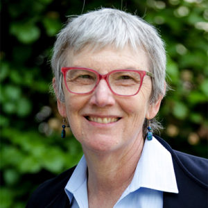 woman wearing a NOAA polo, blazer, and red-rimmed glasses
