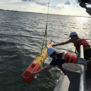 scientists pull a long-range autonomous underwater vehicle from the water