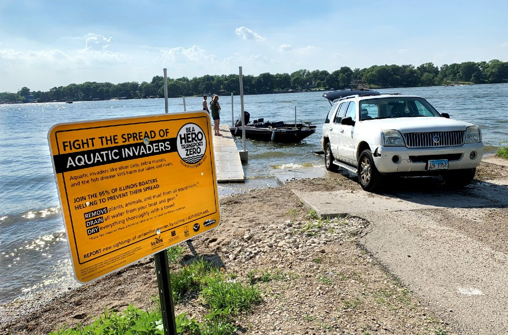 "fight the spread of aquatic invaders" sign next to boat launch