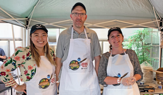 Three people in aprons at the NOAA fish fry.